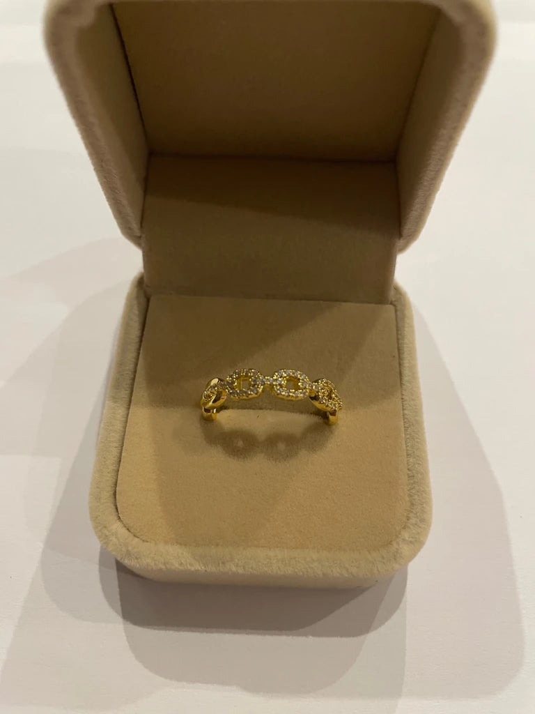 Bague dorée composée de motifs ovales entrelacés ornés de détails scintillants