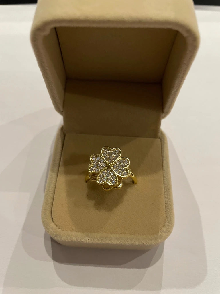 Bague dorée ornée d’un trèfle à quatre feuilles composé de cœurs scintillants