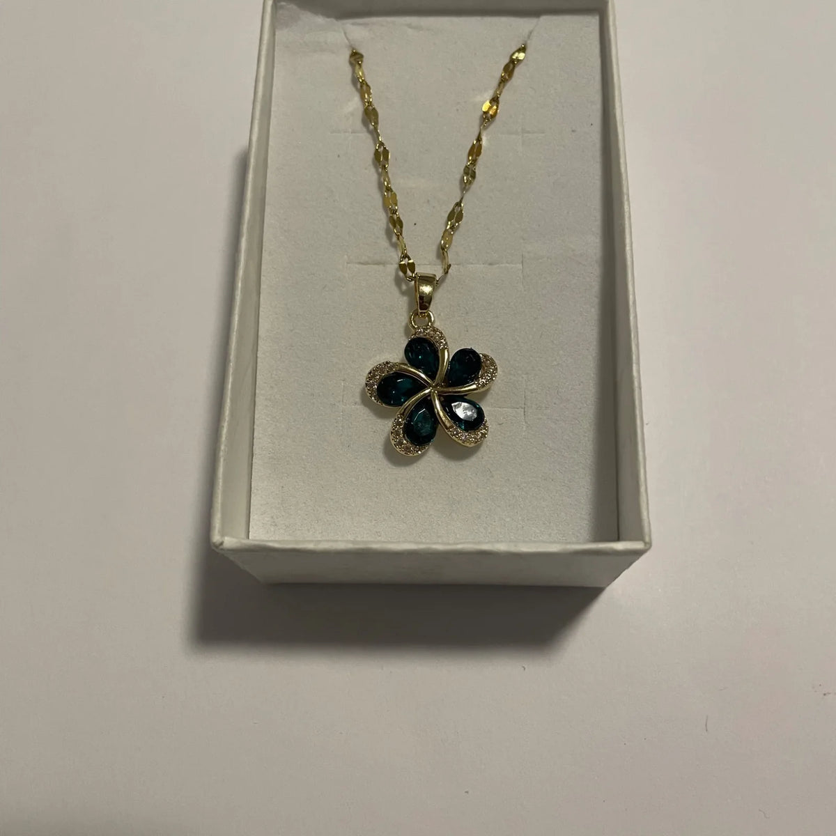 Collier fleur verte doré avec pendentif quatre pétales et strass