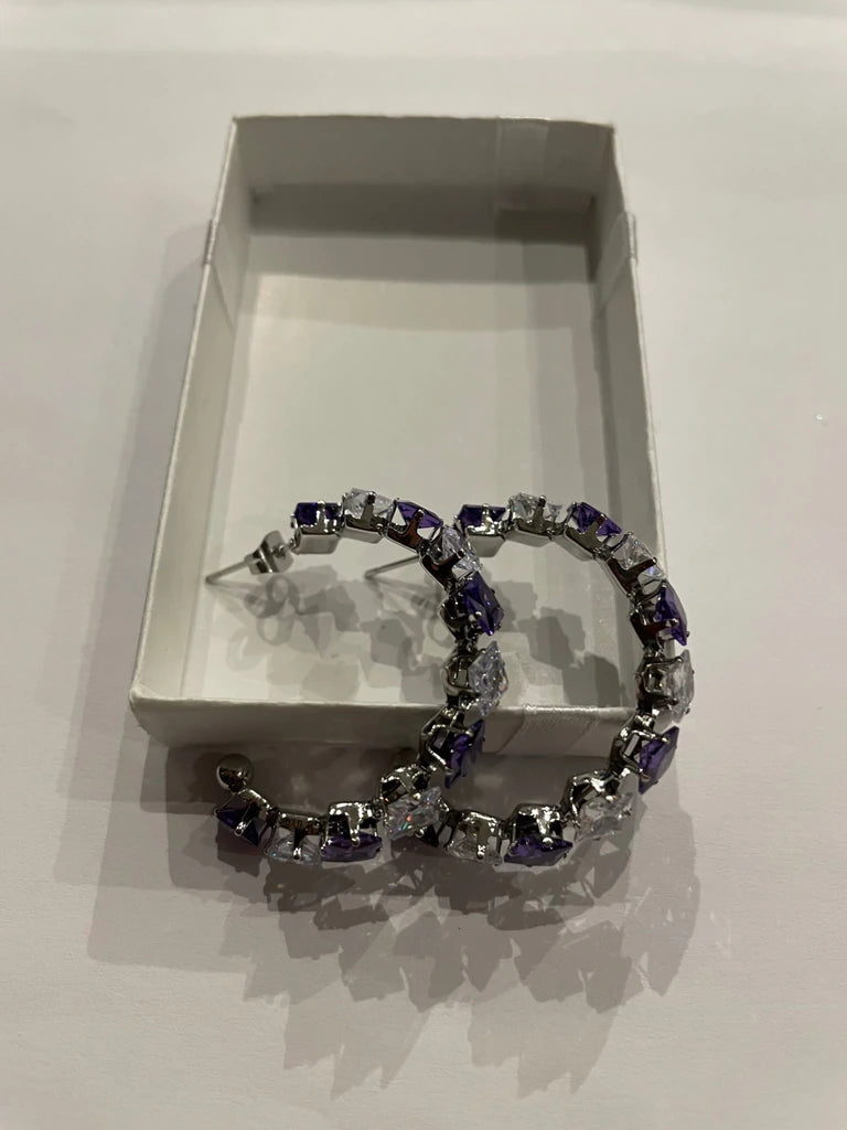 Paire de boucles d’oreilles argentées ornées de pierres violettes et transparentes