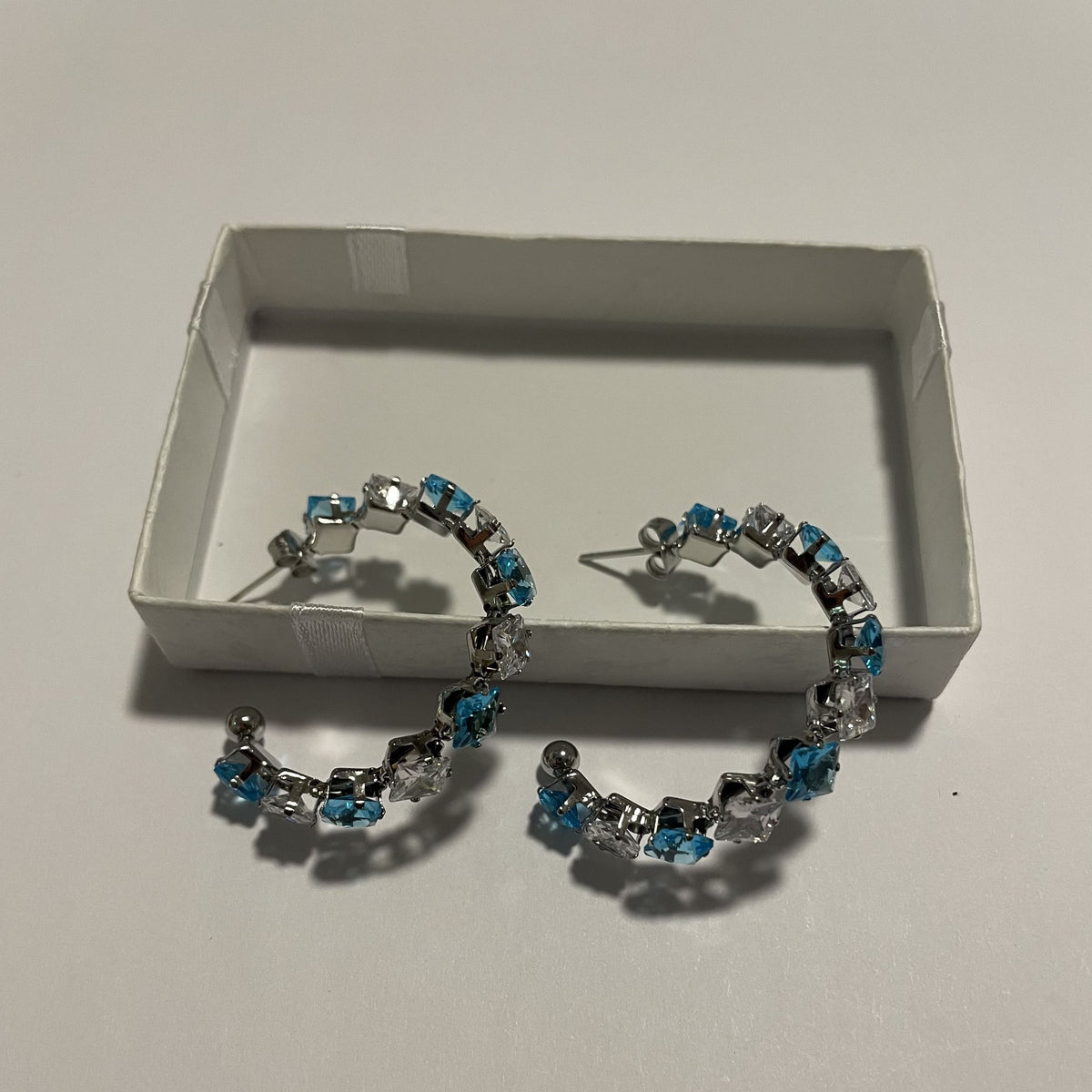 Boucles d'oreilles créoles bleues et blanches avec détails argentés
