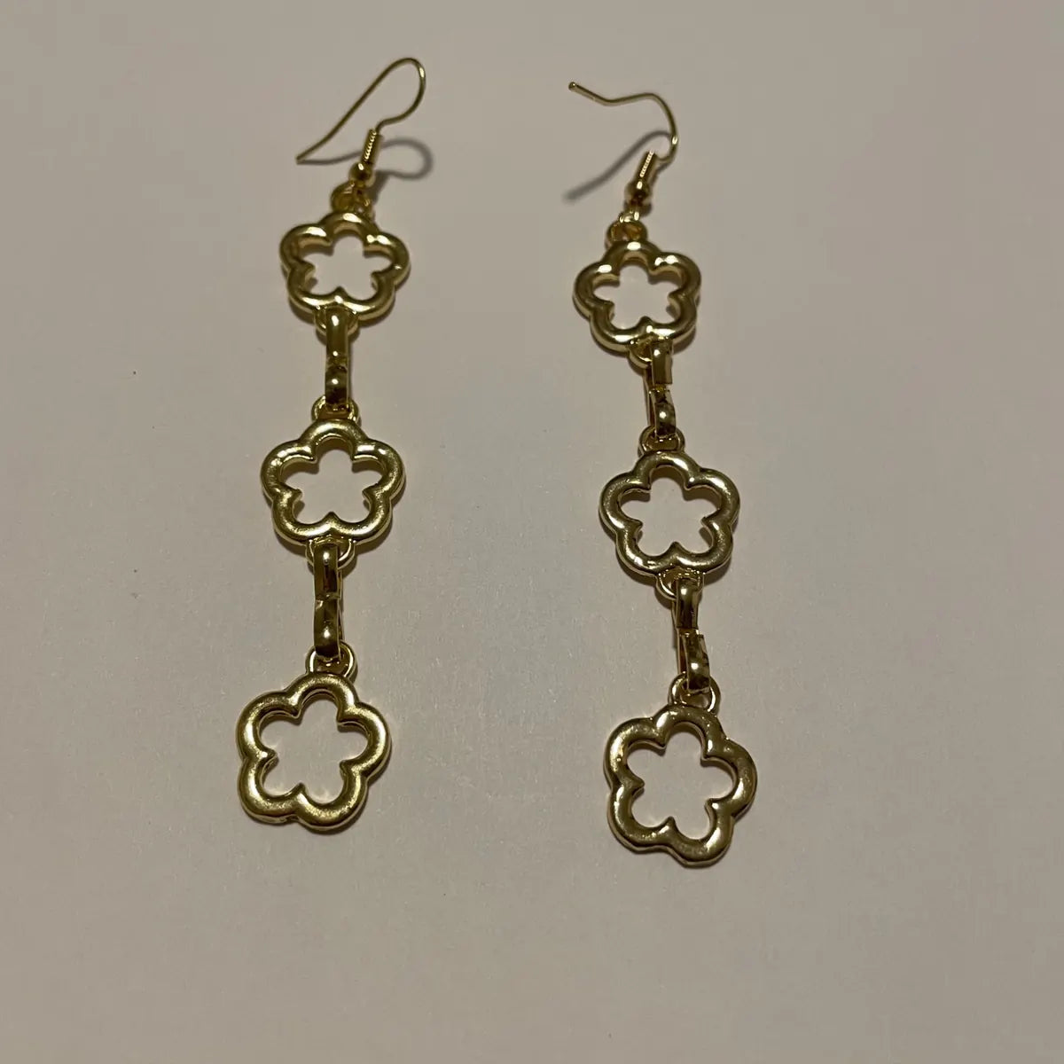 Boucles d'oreilles fleurs dorées pendantes avec trois motifs floraux ajourés