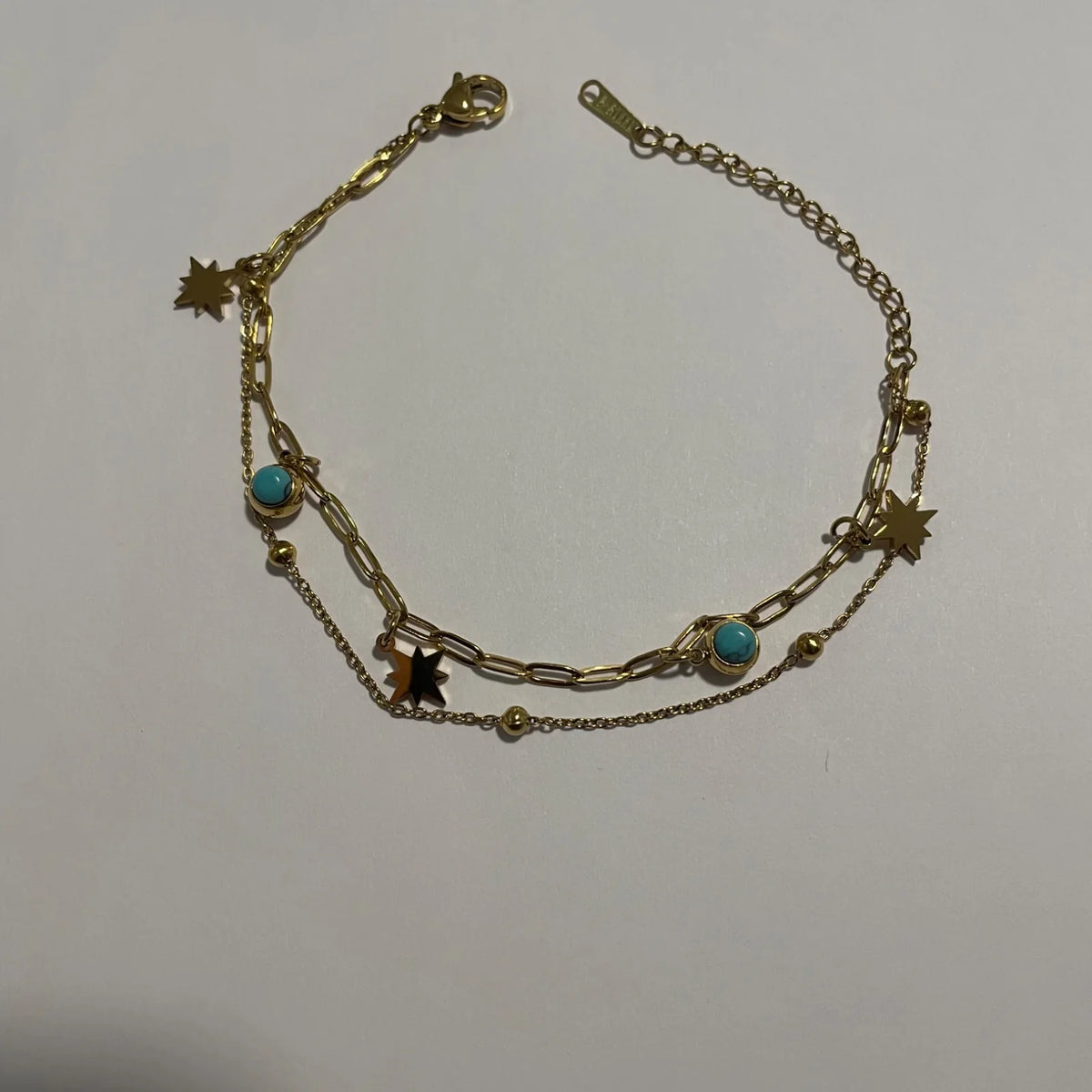 Bracelet double rang doré avec pampilles étoiles et éléments effet turquoise