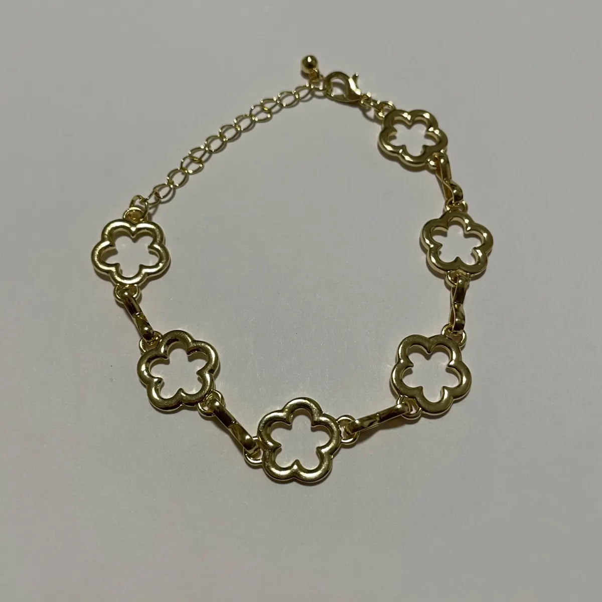 Bracelet fleurs doré pour femme avec motifs floraux ajourés et chaînette réglable