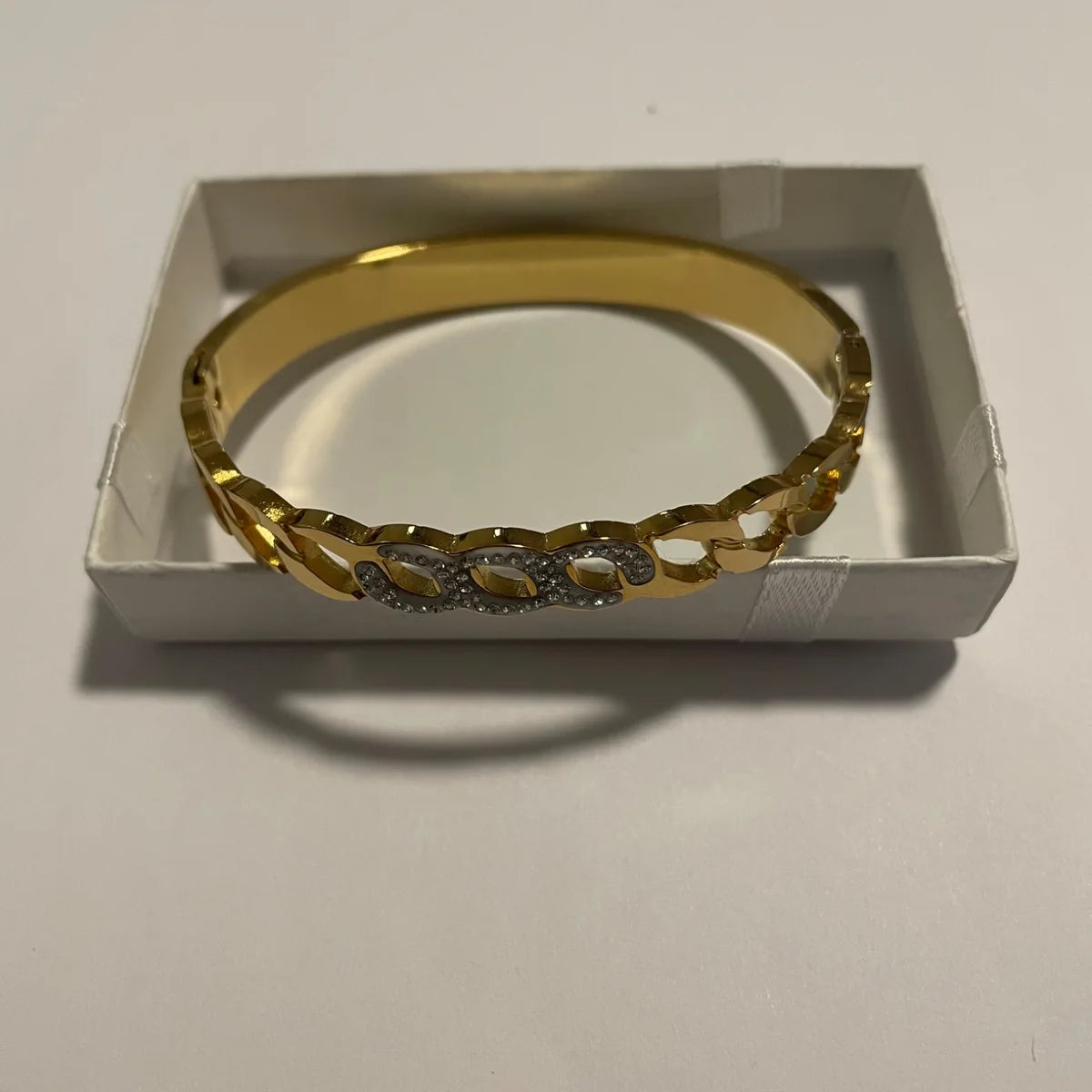 Bracelet jonc doré rigide avec motif ajouré et détails scintillants