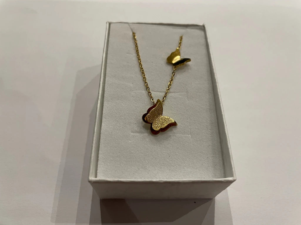 Collier doré orné d’un pendentif papillon et d’un second papillon sur la chaîne