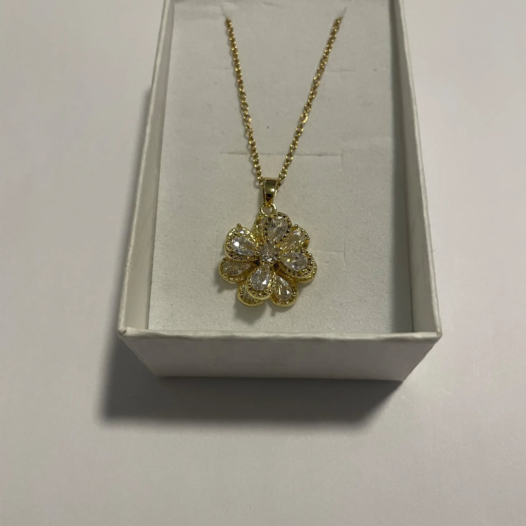 Collier fleur doré avec pendentif tournant et pétales transparents facettés