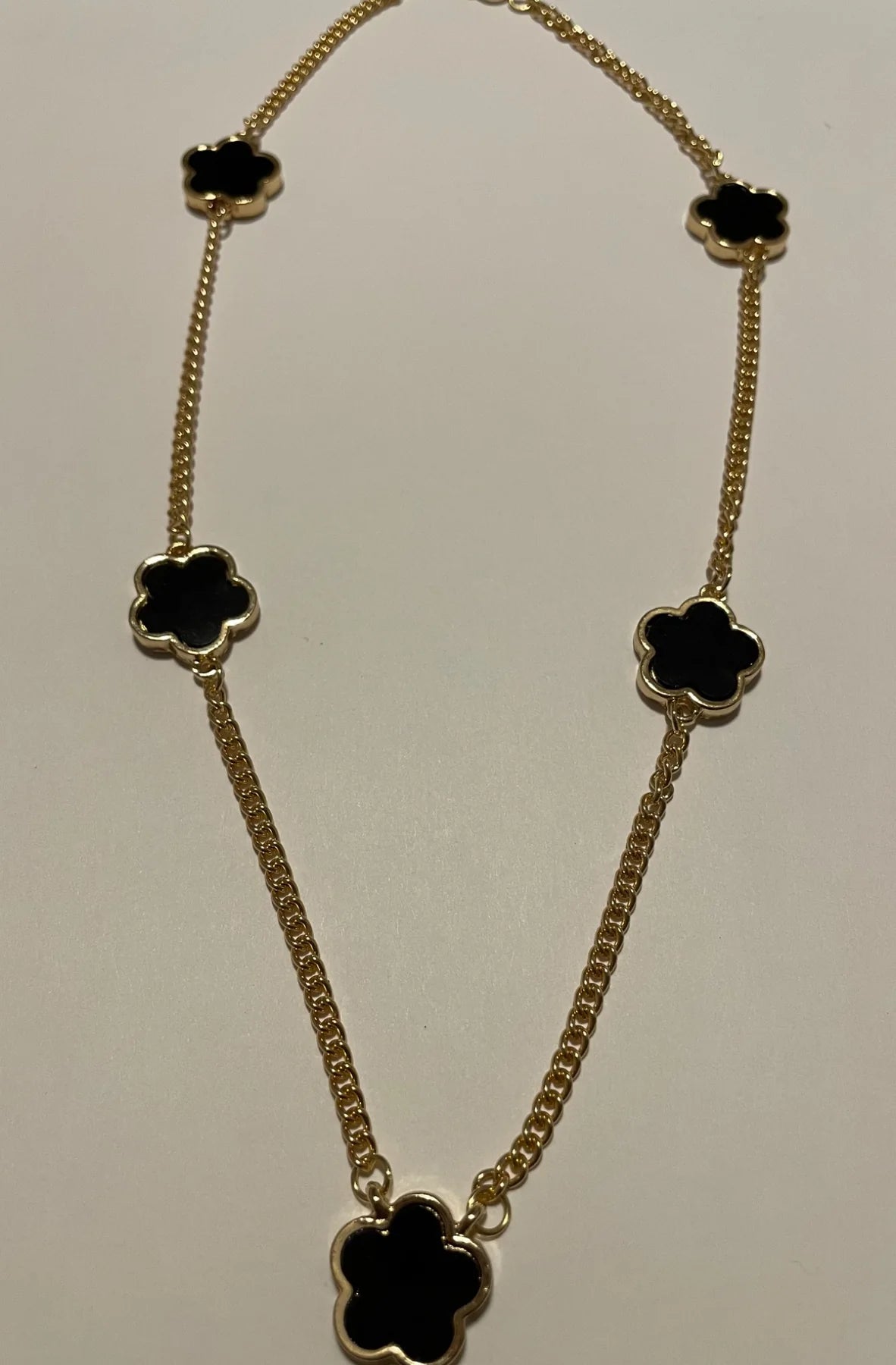 Collier femme doré orné de cinq fleurs noires