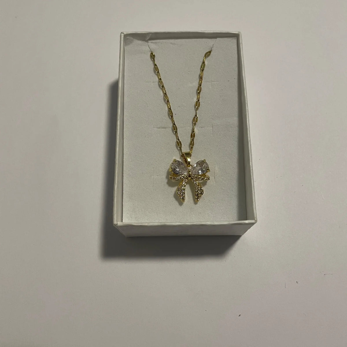 Collier nœud doré orné de strass et éléments transparents