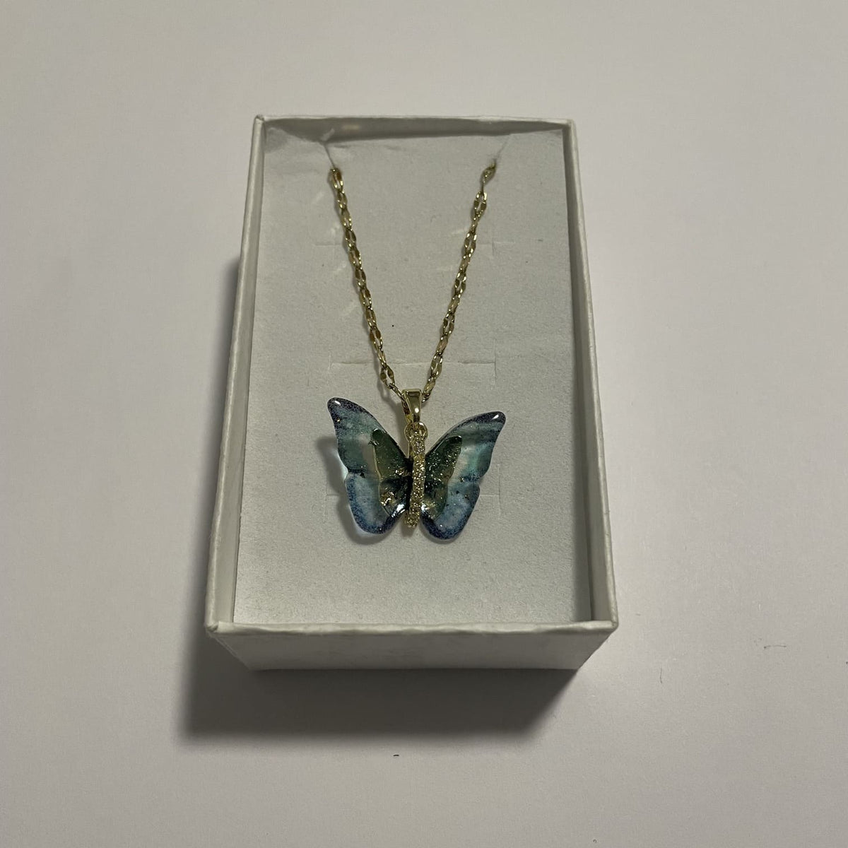 Collier papillon bleu turquoise irisé doré 