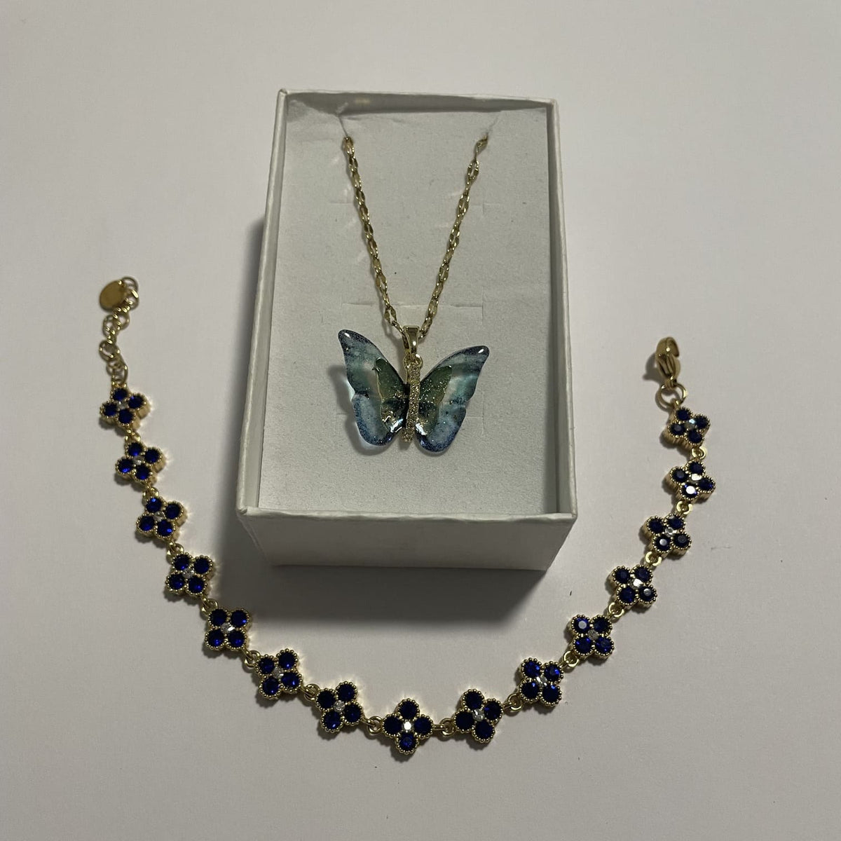 Coffret bijoux papillon bleu avec collier irisé et bracelet fleurs bleu saphir