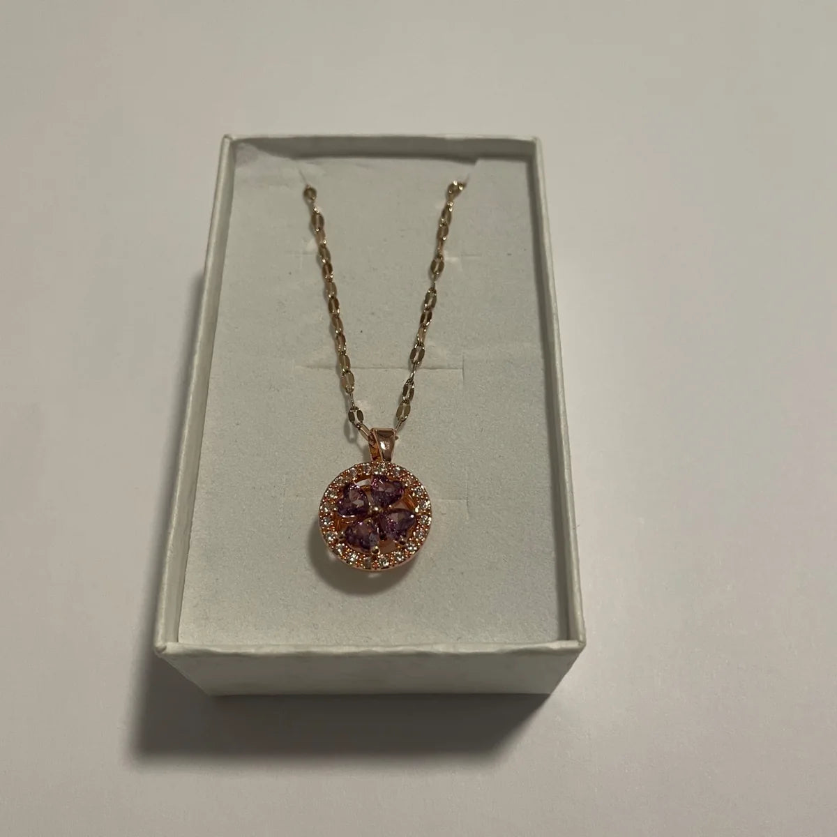 Collier doré avec pendentif rond aux détails violets facettés