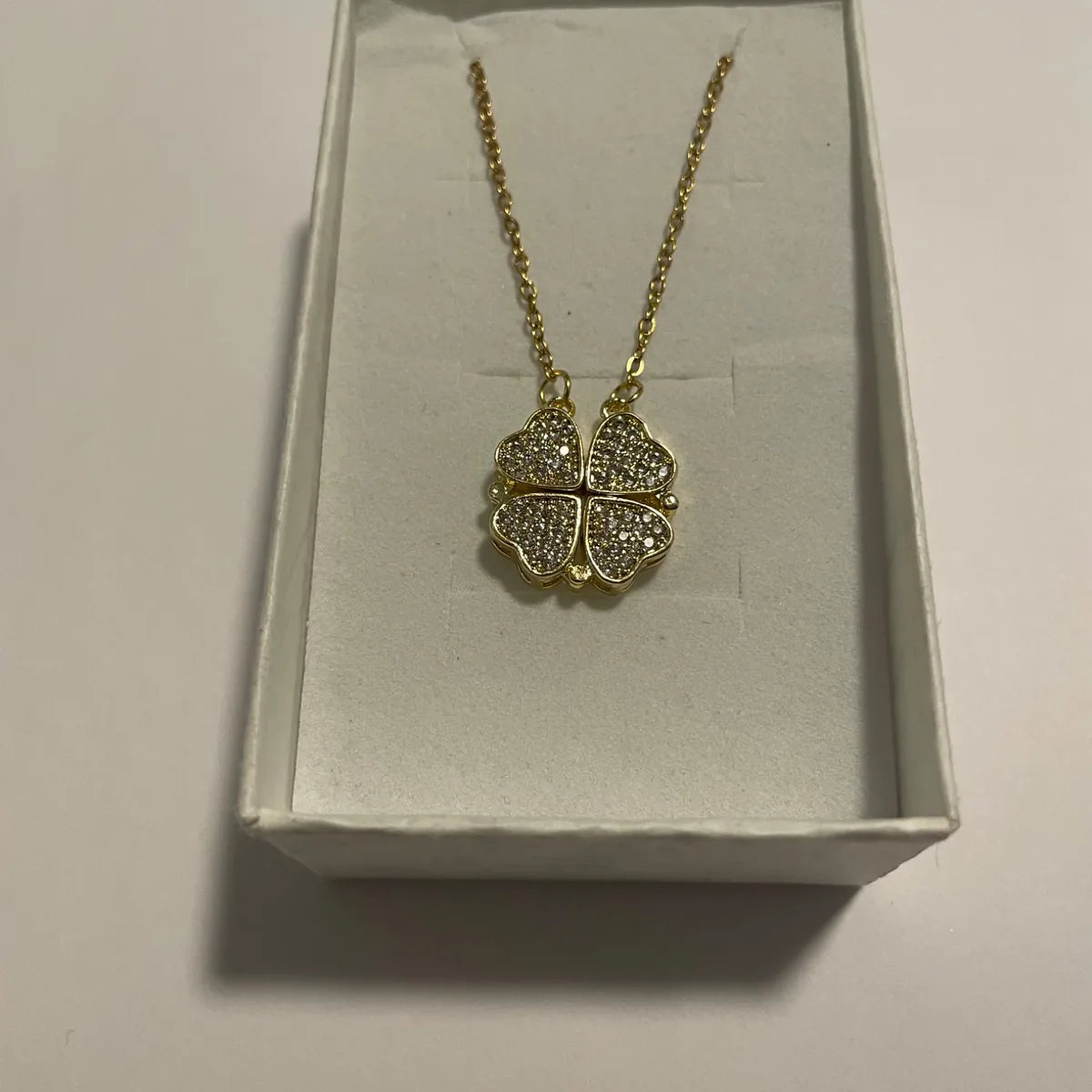 Collier transformable doré avec pendentif trèfle composé de quatre cœurs scintillants