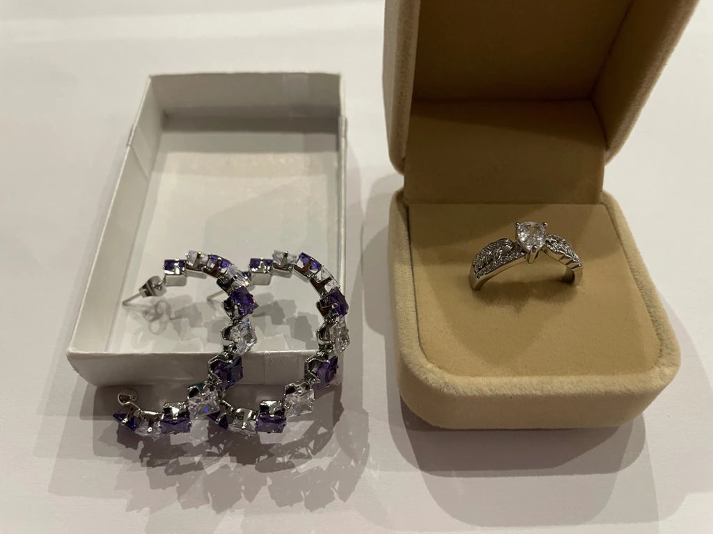 Parure composée d’une bague argentée et de boucles d’oreilles violettes et transparentes