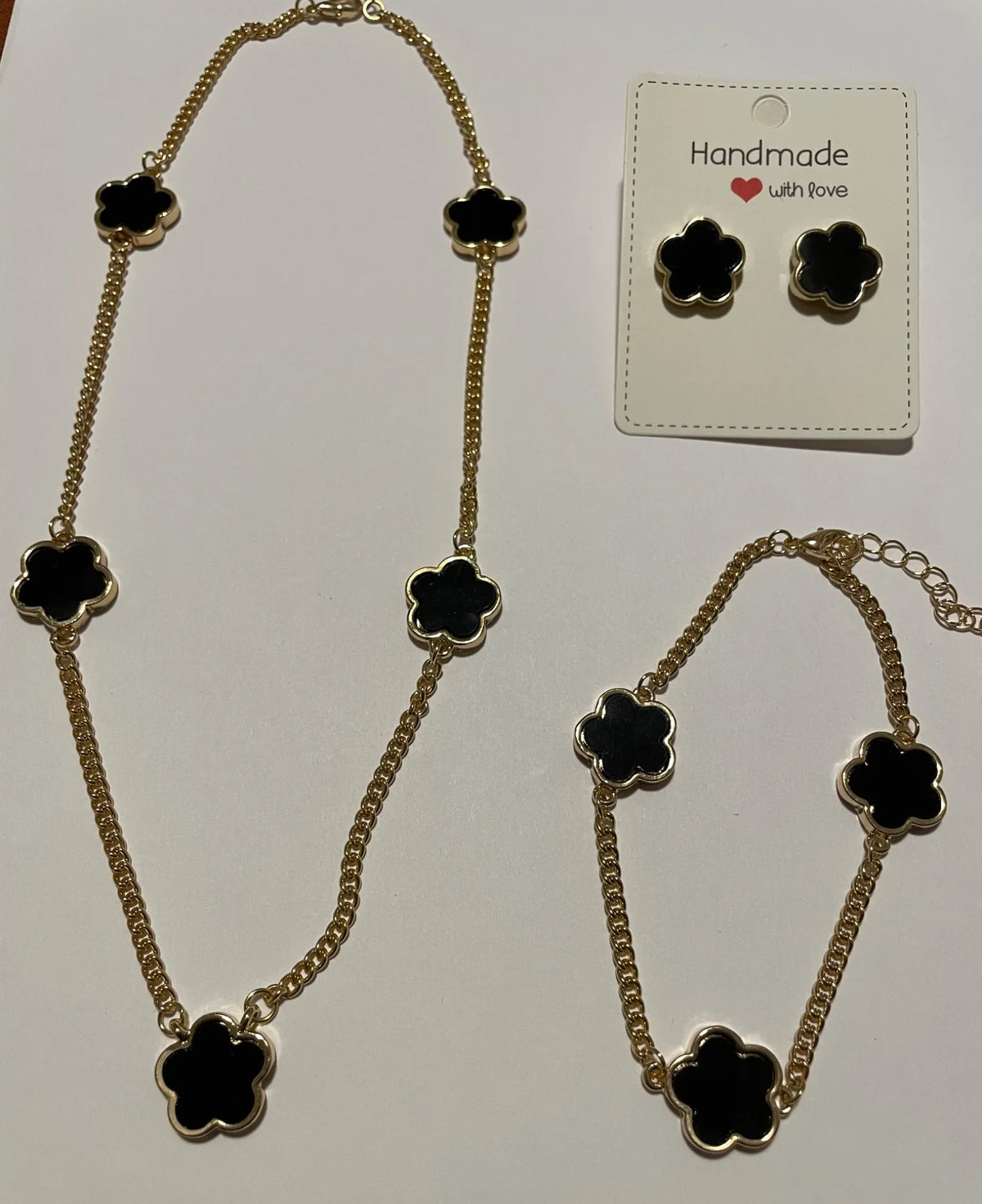 Parure bijoux femme noire et dorée à fleurs avec collier, bracelet et boucles d’oreilles