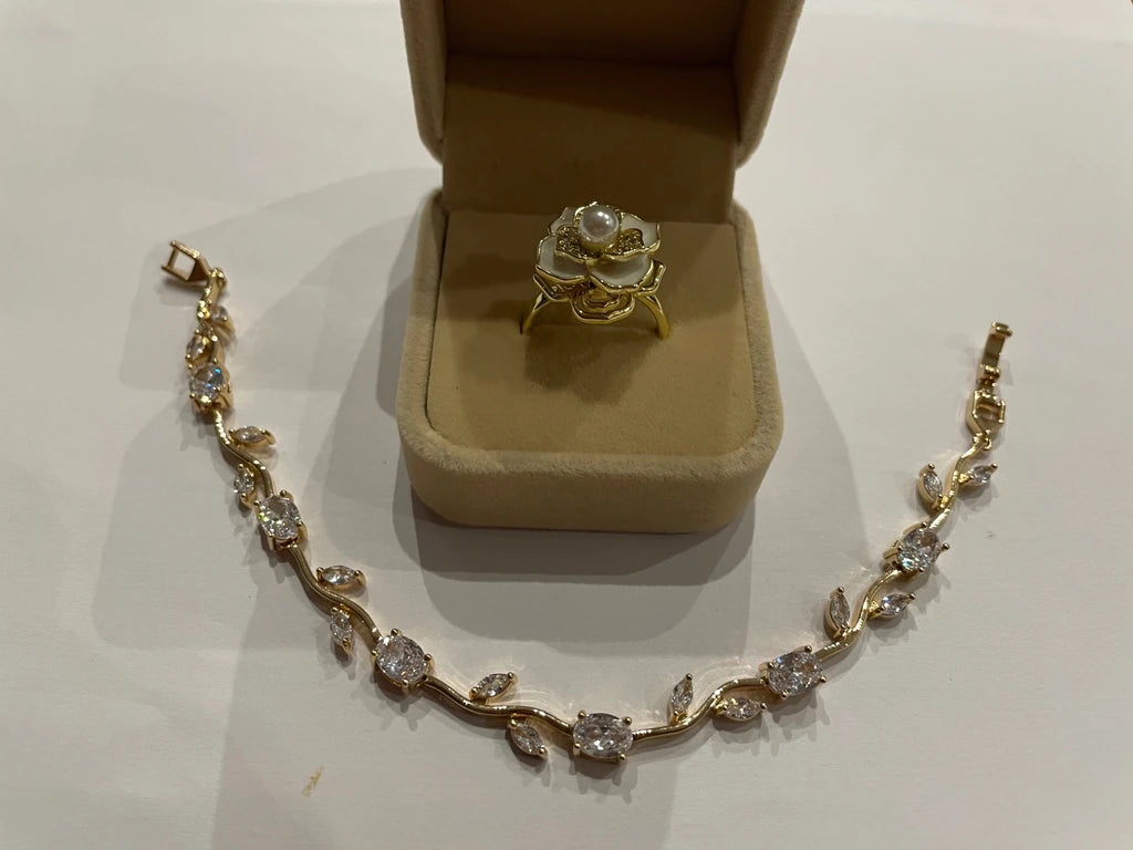 Parure dorée composée d’une bague rose blanche et d’un bracelet feuillage scintillant