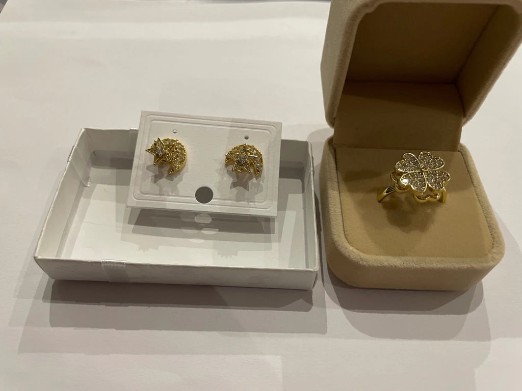 Parure dorée composée d’une bague trèfle et de boucles d’oreilles lune et étoile